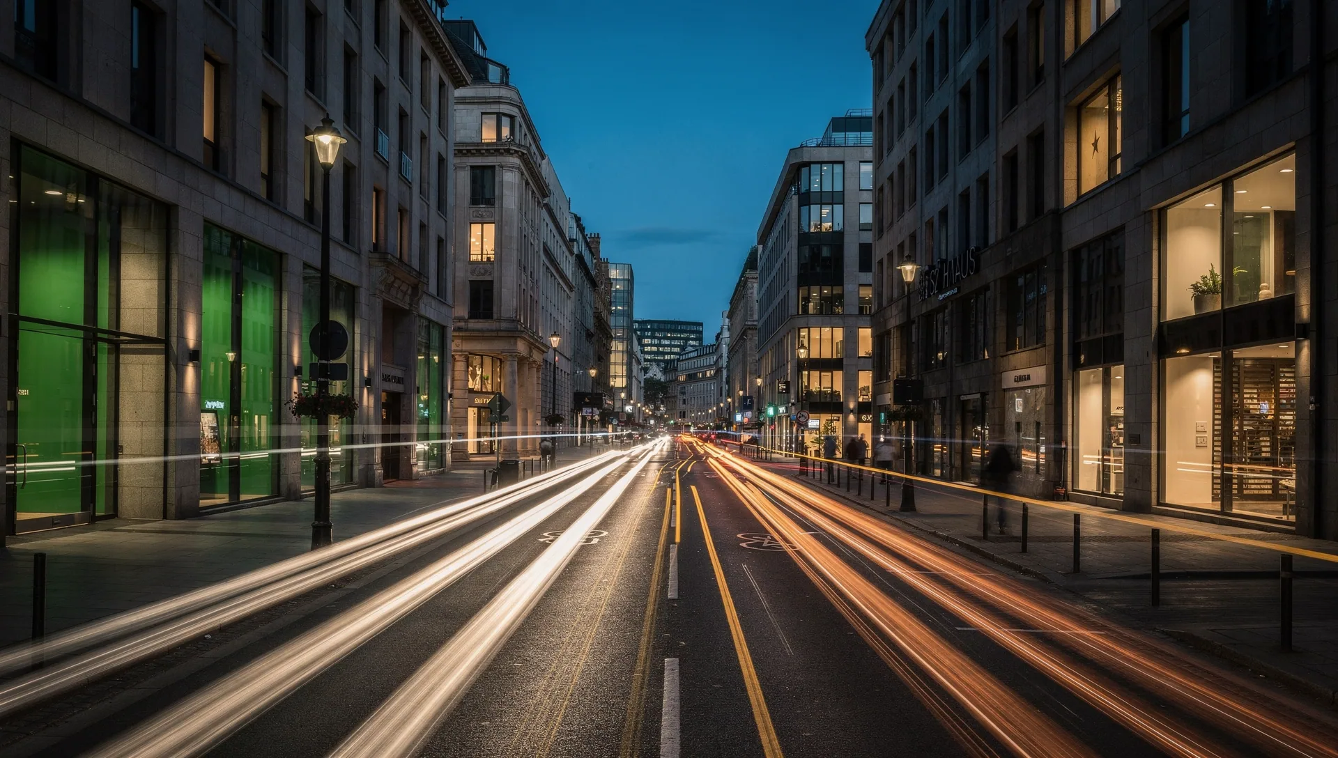 White and amber light trails leading along a European city street at night